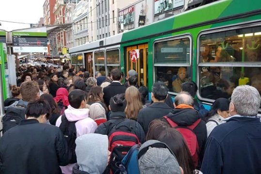 passengers struggling to get on packed tram