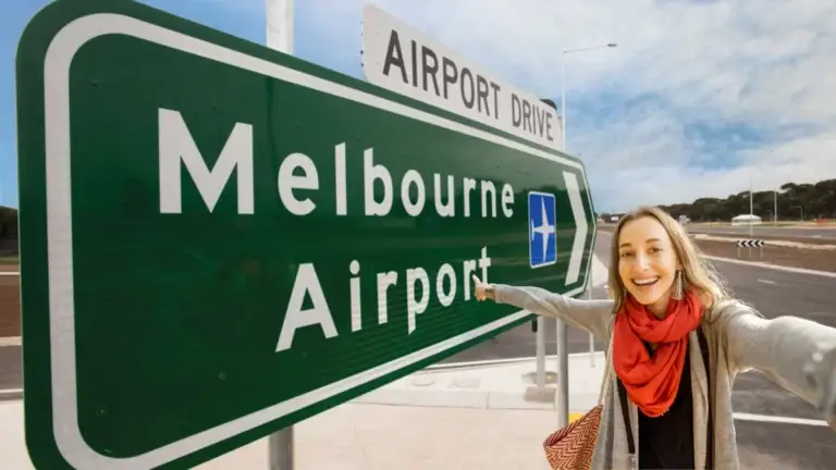 Smiling traveller pointing at Melbourne Airport sign — BagBoyz® luggage pick-up and delivery service for airport arrivals